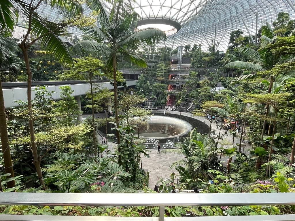 Khu vườn nhiệt đới trong nhà dưới mái vòm kính, có thác nước hình phễu ở giữa